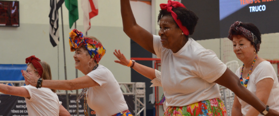Imagem colorida de mulheres dançando nos Jogos Municipal da Pessoa Idosa