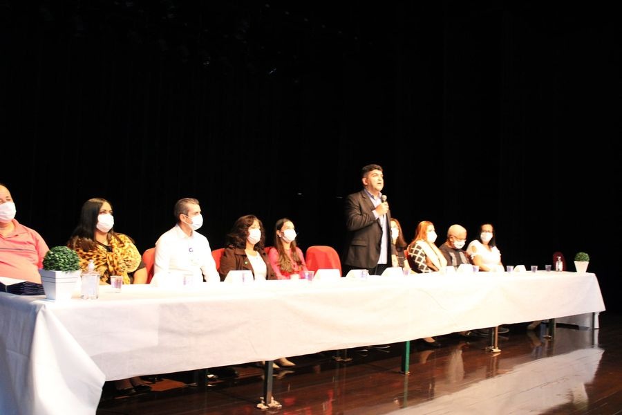 Foto do subprefeito Guilherme Henrique falando entre membros da mesa da cerimônia de posse dos conselheiros gestores de saúde.