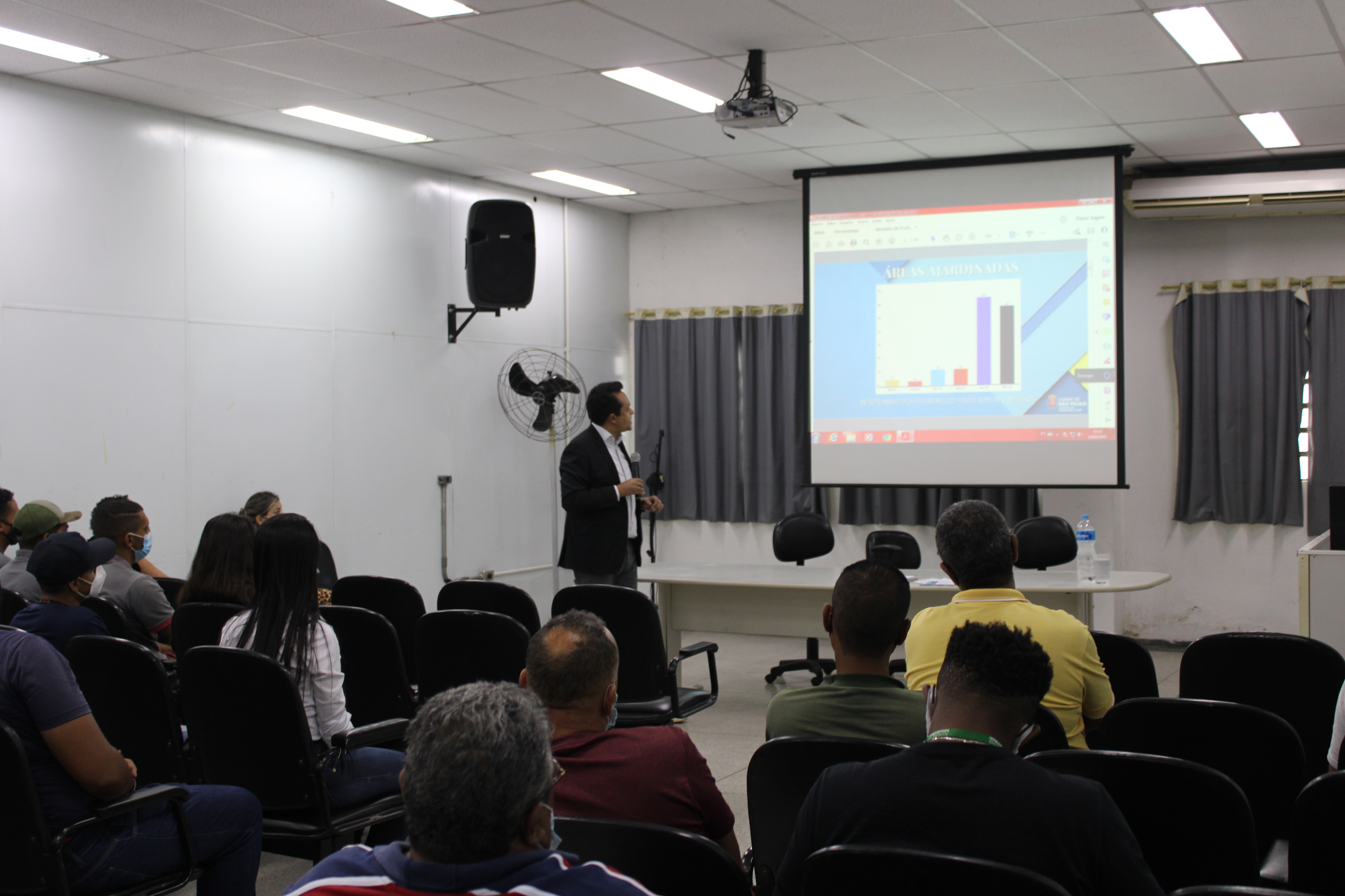 Na imagem aparece o Subprefeito do Itaim Paulista, Gilmar Santos, apresentando dados na reunião com os encarregados de zeladoria no auditório da Subprefeitura Itaim Paulista.