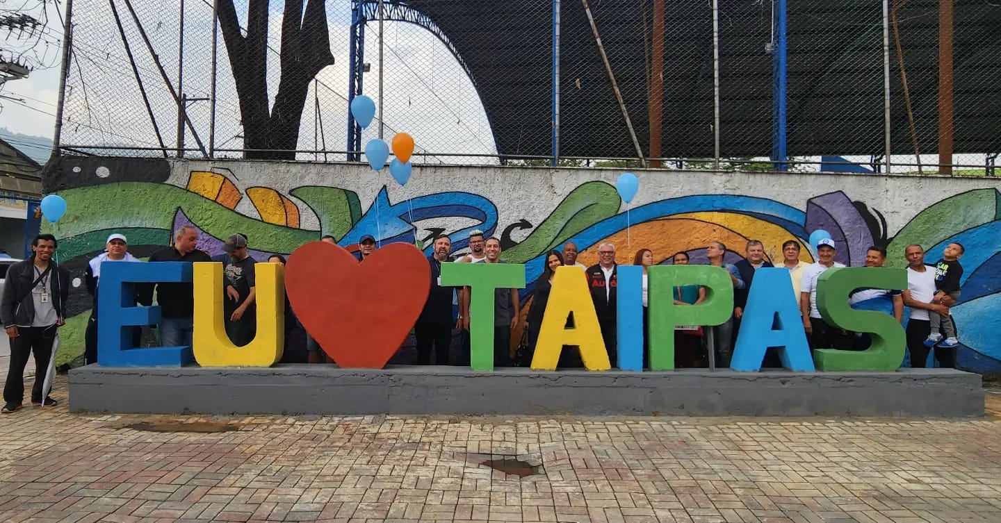 Letreiro de Taipas com letras grandes e coloridas, contendo um coração no meio do "Eu" e "Taipas"