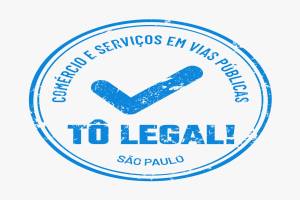 Círculo com letras e contorno em azul claro descrevem o Tô Legal comércio e serviços em vias públicas de São Paulo