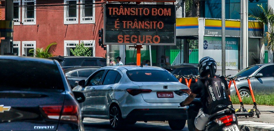 A imagem possui o trânsito de São Paulo com carros e motos