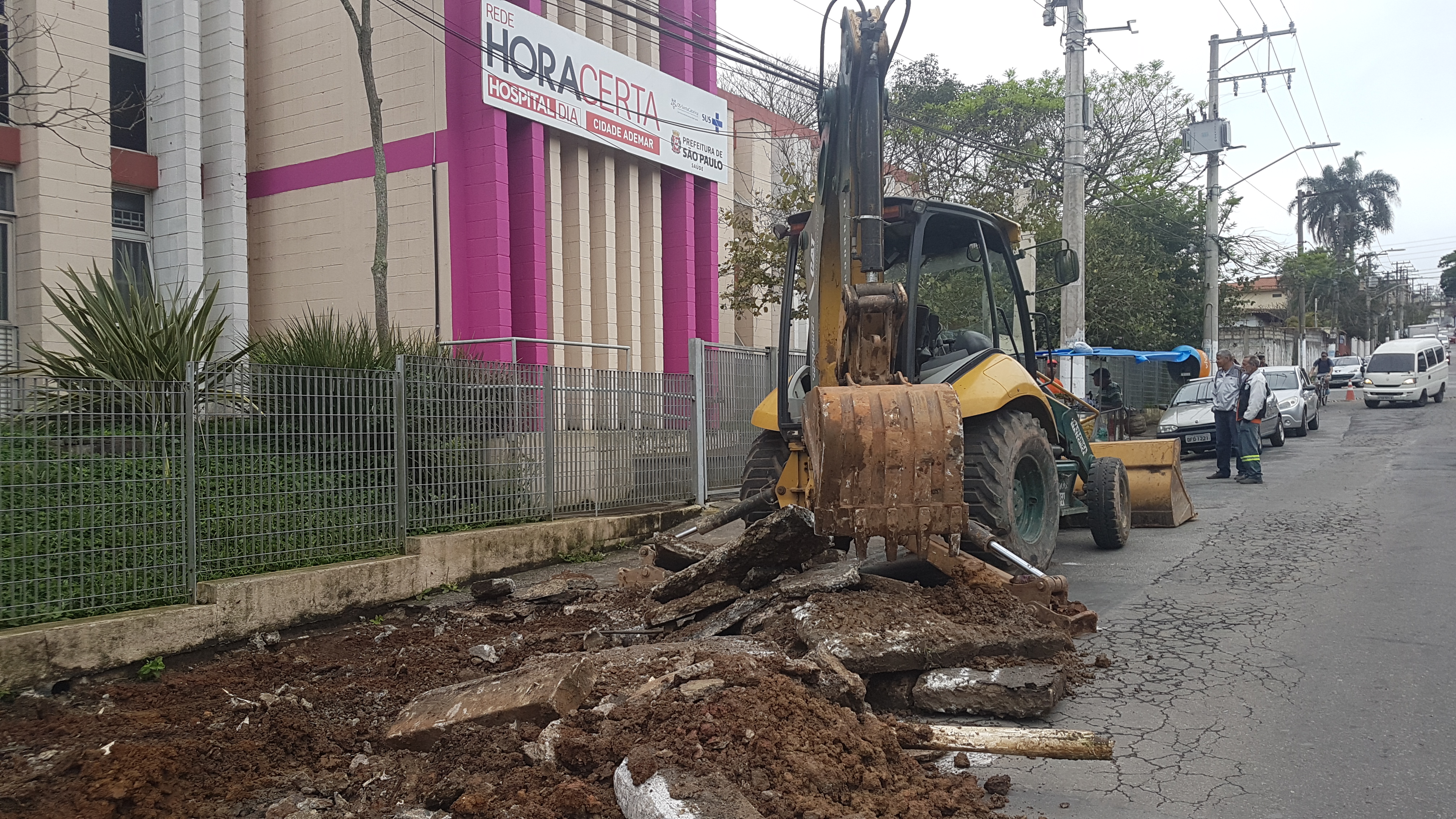 Trator em frente a um hospital Hora Certa está retirando o entulho da calçada que está foi quebrada para sua reforma