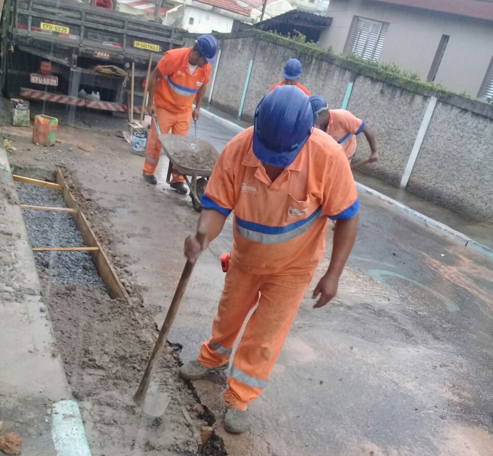 Servidores da prefeitura tapando um buraco e carregando os entulhos