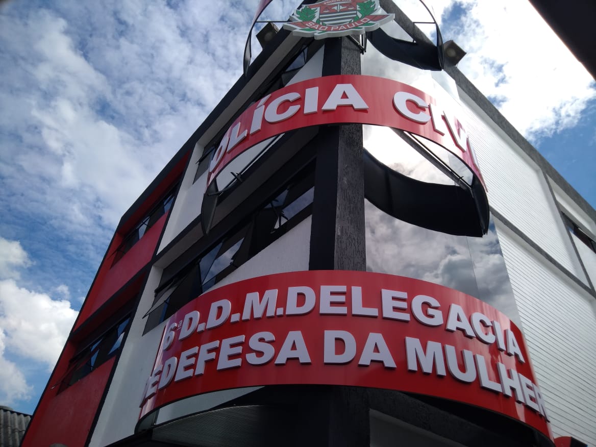 O prédio da nova Delegacia da Mulher com o letreiro acima com a frase "Polícia Civil" e outro letreiro logo abaixo com a frase "6ª D.D.M. Delegacia de Defesa da Mulher"