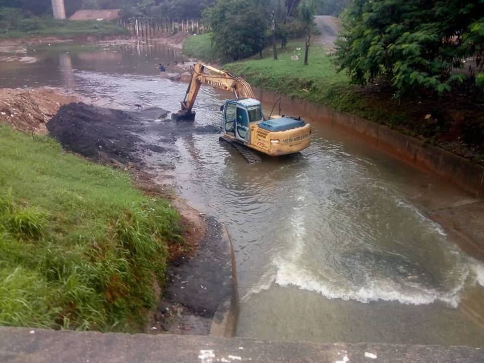 Espaço grande como um lago, e uma escavadeira retirando a sujeira do meio.