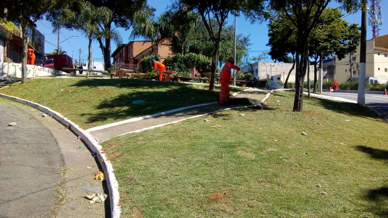 Área verde homens uniformizados cortando o mato 