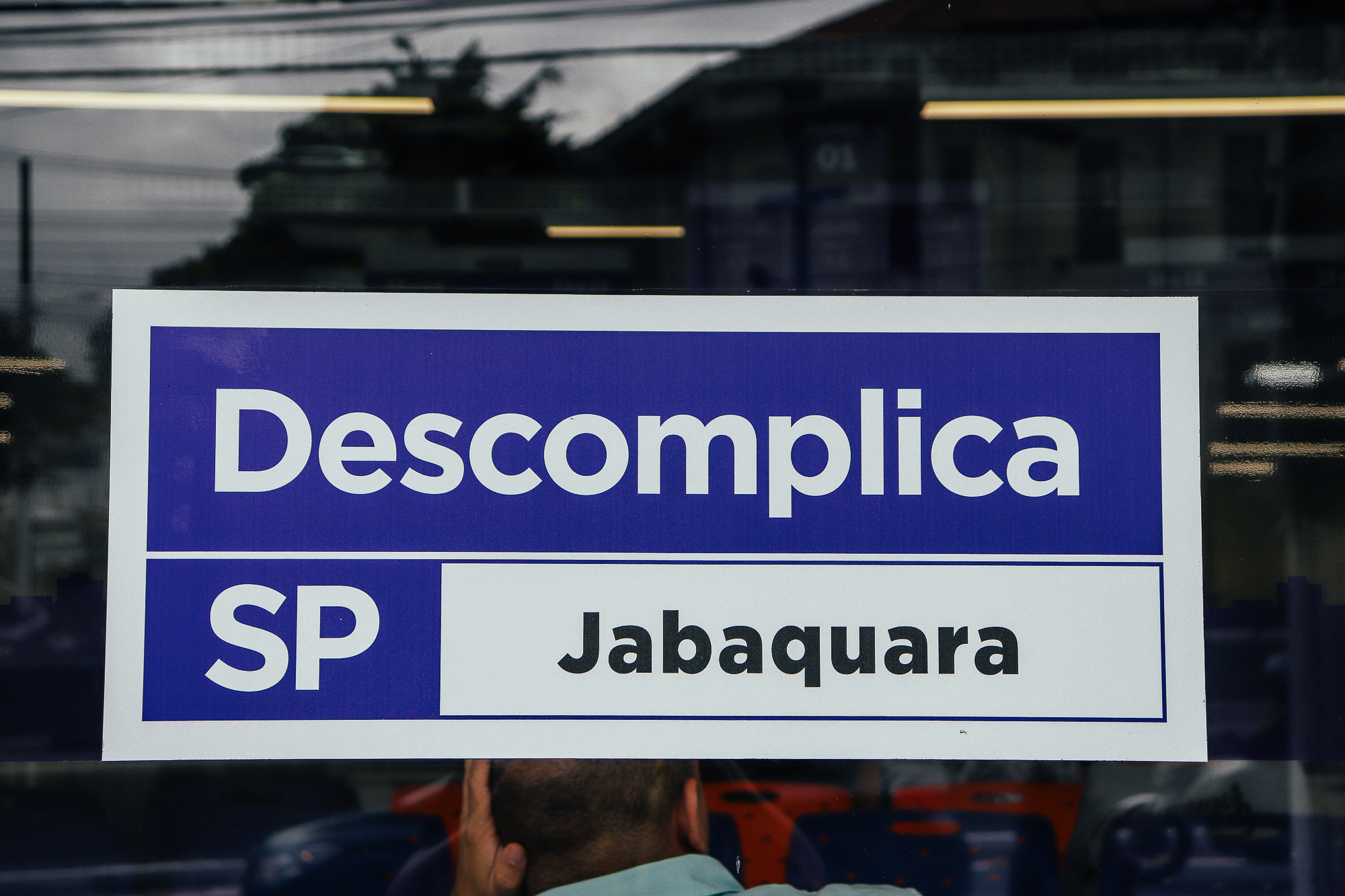 Placa do Descomplica SP - Jabaquara em uma porta de vidro