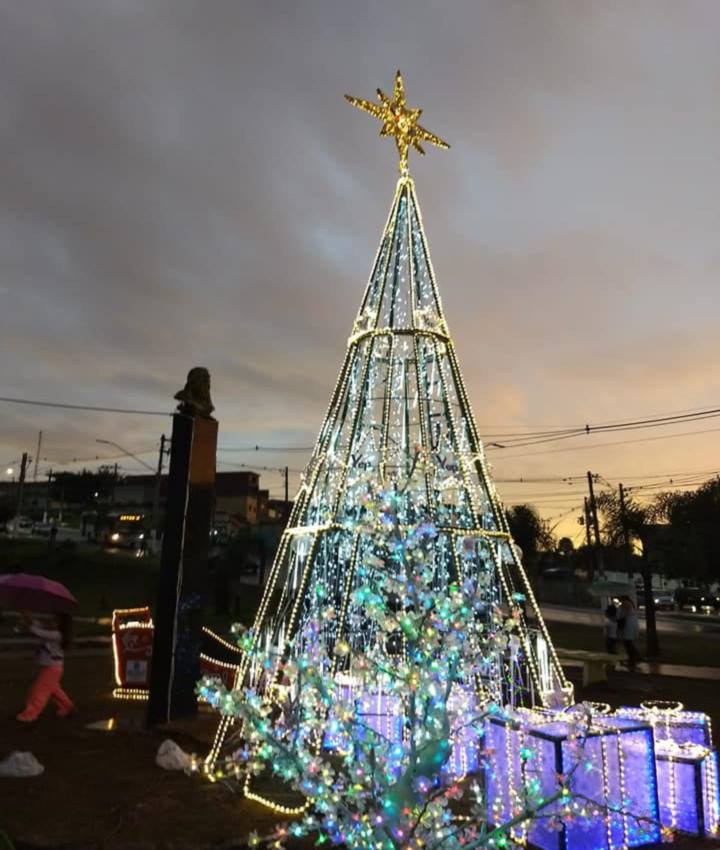 Árvore de Natal de seis metros montada na praça  tem estrela iluminada na ponta e ao fundo o busto de Tiradentes