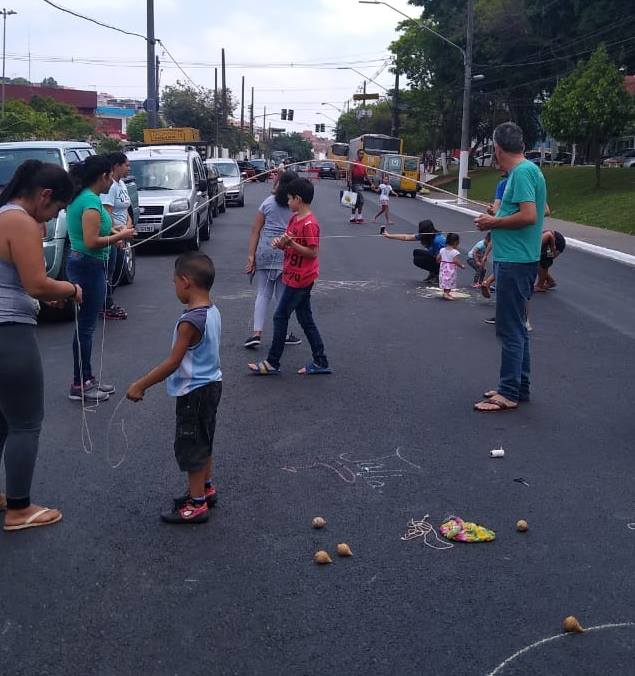 Na Avenida Metalúrgicos monitores brincam com as crianças de pula corda e jogo de pião