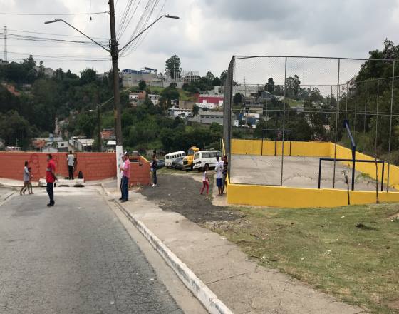 momento quase final da ação com muros reformados e construção de área para os conteineres, quadra de esportes e mobiliários pintados na cores verde e amarelo                          pintada