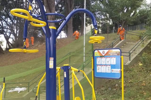 Imagem com equipe de limpeza e ATIs em destaque e homens trabalhando ao fundo 