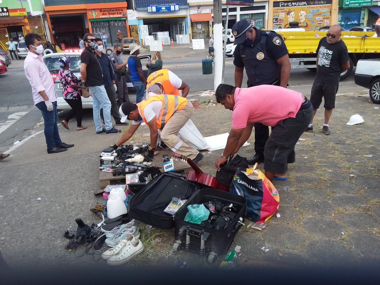 Equipe de fiscais fazem apreensão de objetos vendidos em lona estendida no chão de uma praça