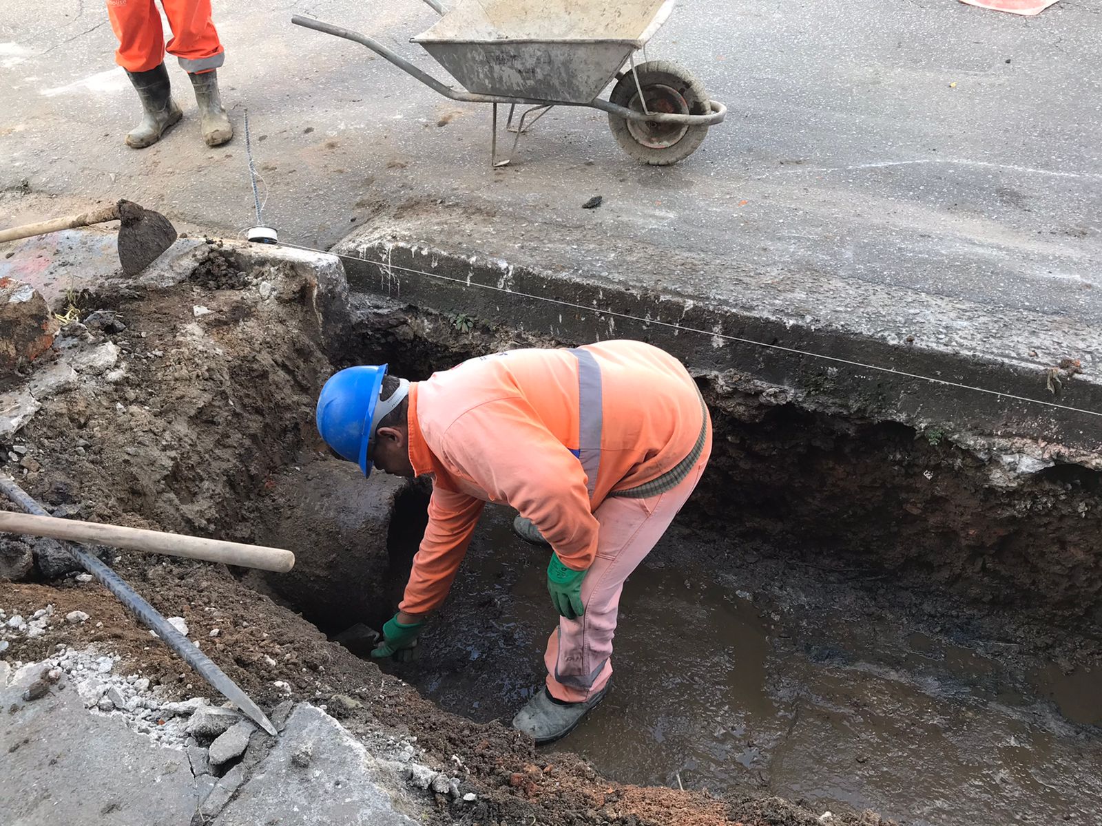 Imagem do funcionário dentro da boca de lobo que recebeu os serviços de reconstrução, na avenida Jardim Japão