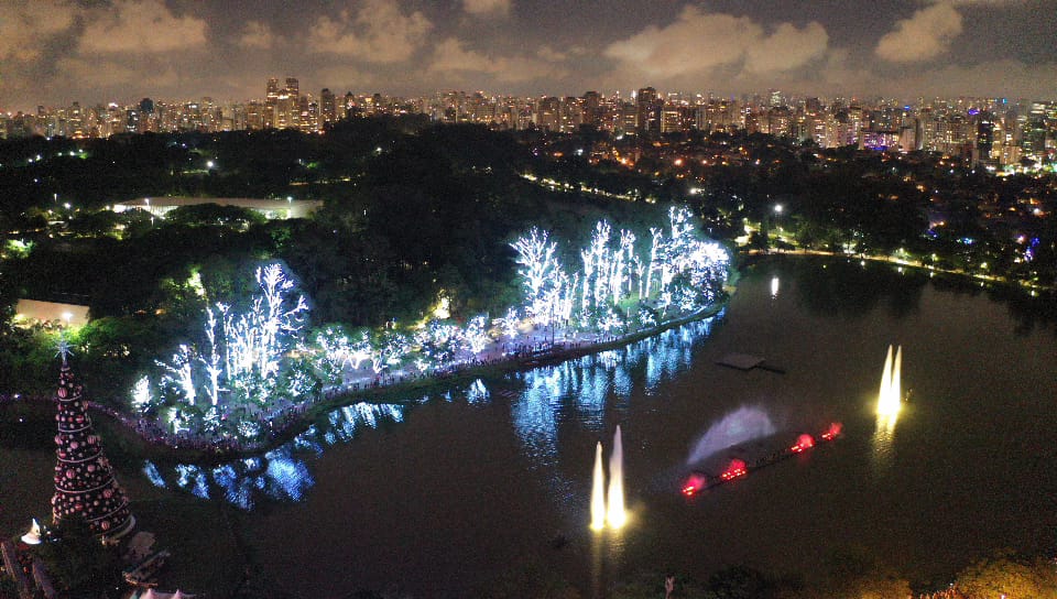 foto aérea do parque ibirapuera com o lago, a árvore de natal e a fonte iluminada