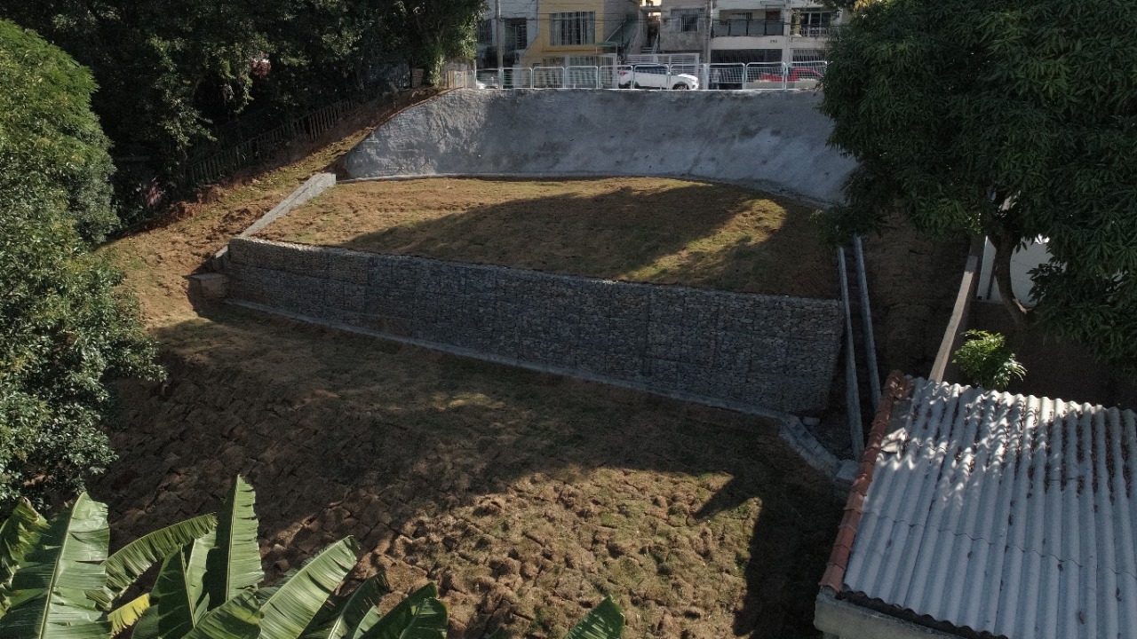 foto aérea da obra de contenção de talude na Praça Julio Cesar Vanini. Ao redor do talude, há muitas árvores