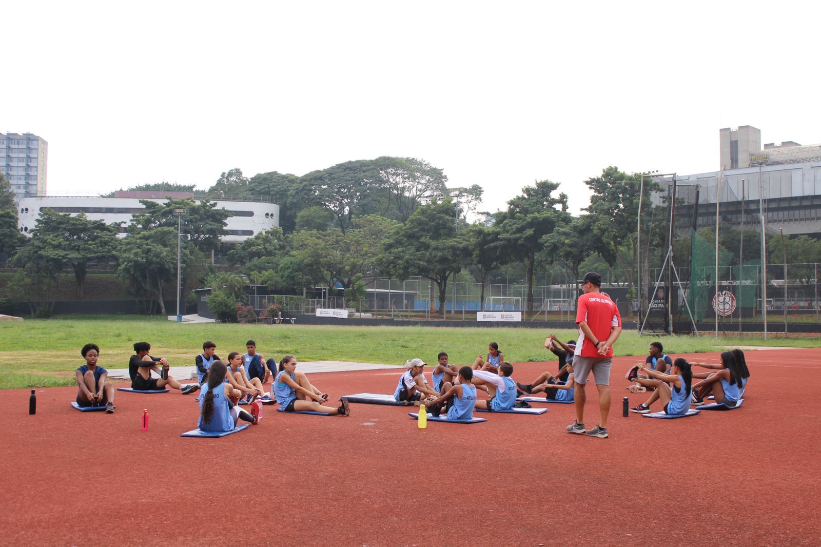 Na imagem, atletas de atletismo do COTP se alongando na pista de atletismo.