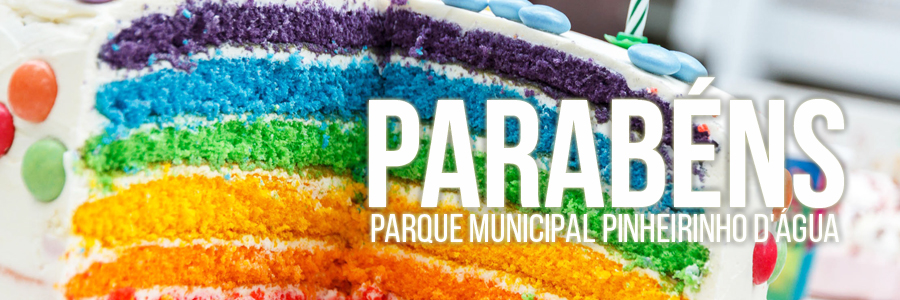 Bolo com massa e confeitos nas cores do arco-íris. Ao centro, na parte inferior, estão os dizeres: "Parabéns, Parque Municipal Pinheirinho d'Água".