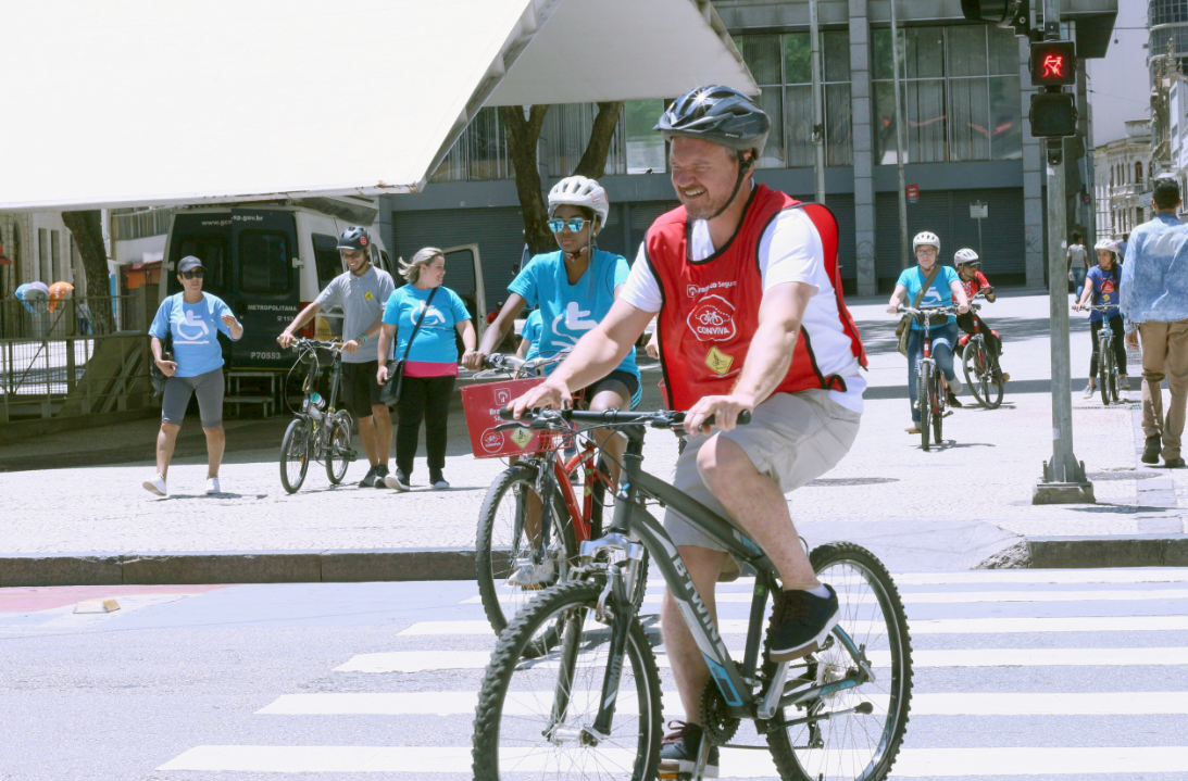 O assesor parlamentar Paullo Vieira atravessa o farol de bicicleta. 