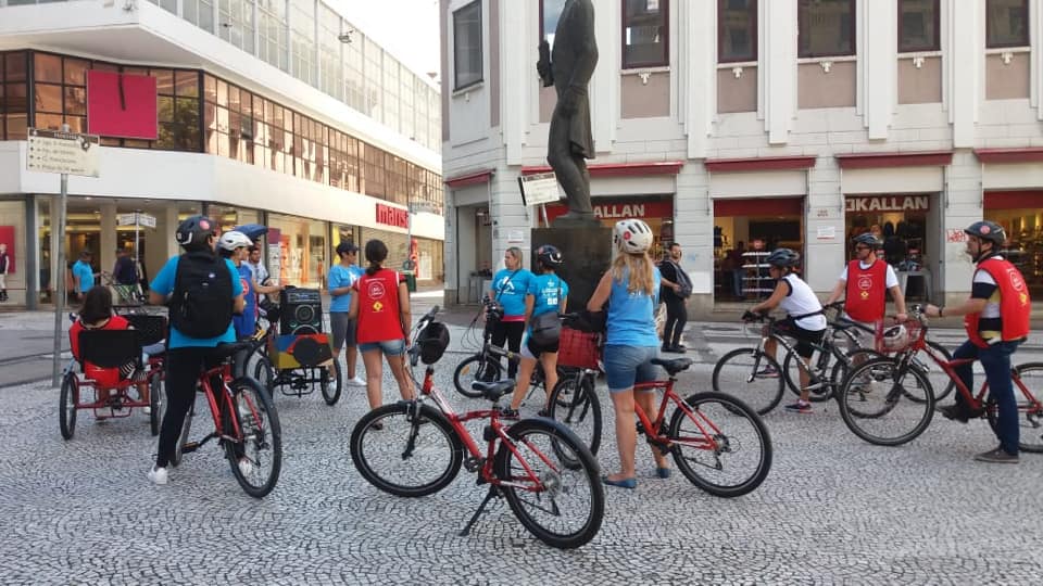 dez pessoas reunidas na Praça Patriarca. Todos estão com equipamentos e bicicletas.