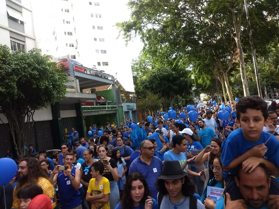 Avenida Paulista cheia. Pessoas usam camisetas na cor azul, balões também na cor azul.