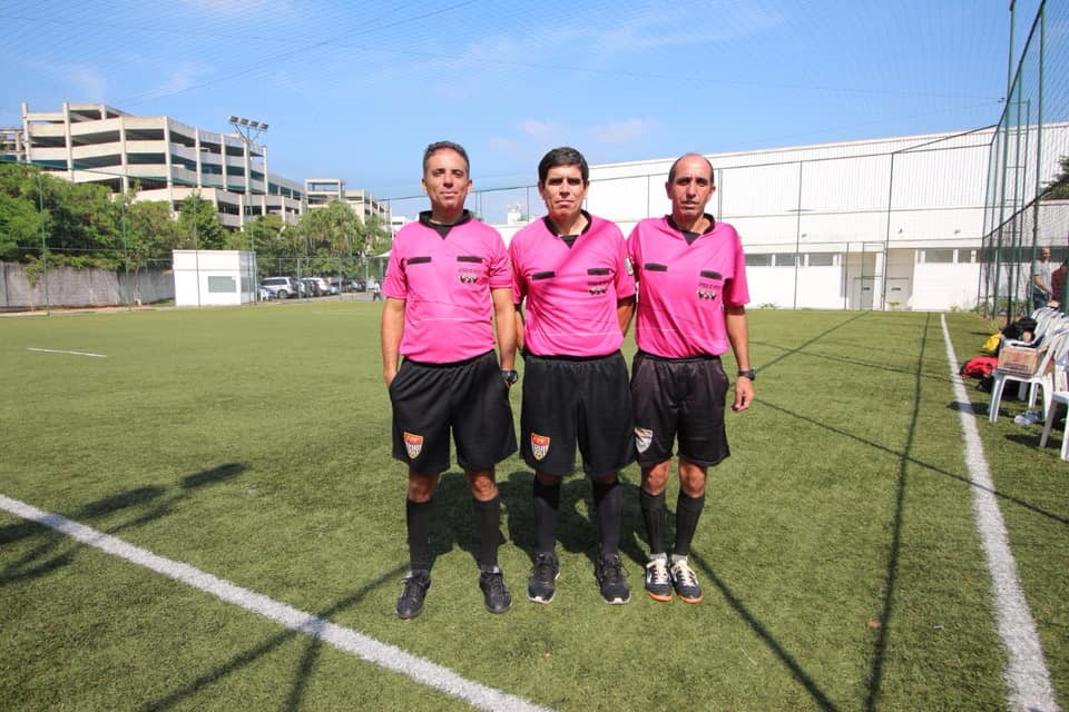 no campo de futebol aberto, os três árbitros. 
