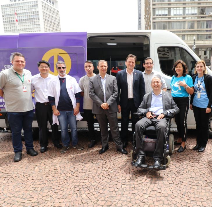 mais de dez pessoas foto. Entre elas, em frente da van, o secretário municipal da SMPED, Cid Torquato e o presidente da AACD. 