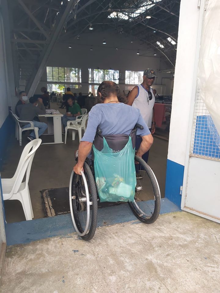no CTA, um homem em uma cadeira de rodas passa pela entrada da porta.