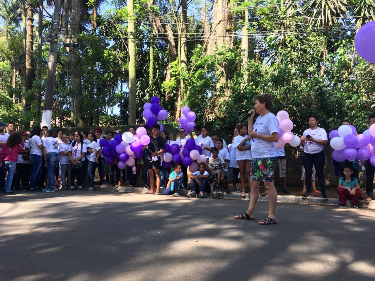 MULHER EMITINDO MENSAGEM A PARTICIPANTES DA CAMINHADA