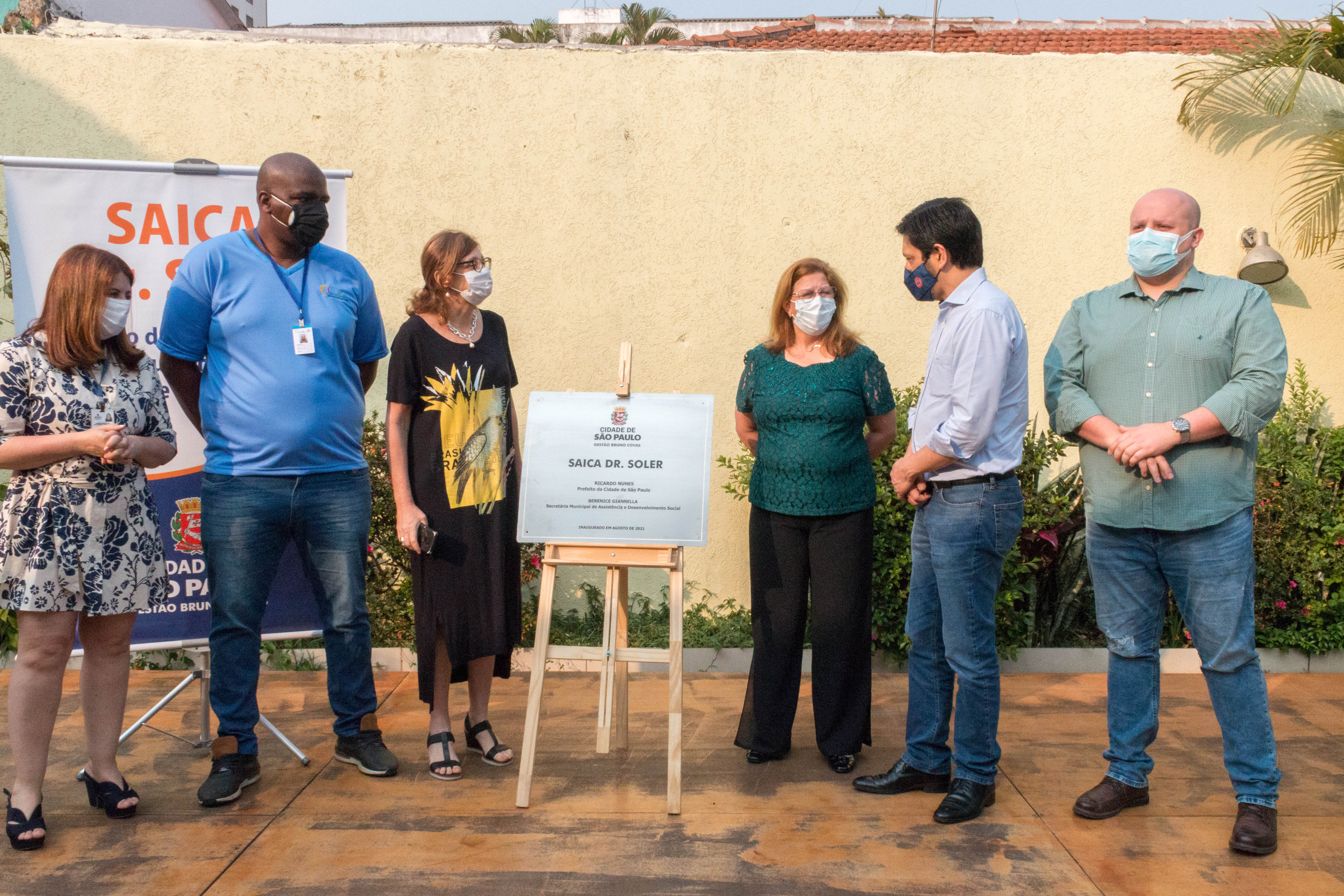 Em cerimônia de descerramento da placa de inauguração, seis pessoas, dentre elas o prefeito Ricardo Nunes, a secretária de Assistência e Desenvolvimento Social, Berenice Giannella, a supervisora de Assistência Social de Aricanduva/Vila Formosa, Débora Ramos dentre outras pessoas.