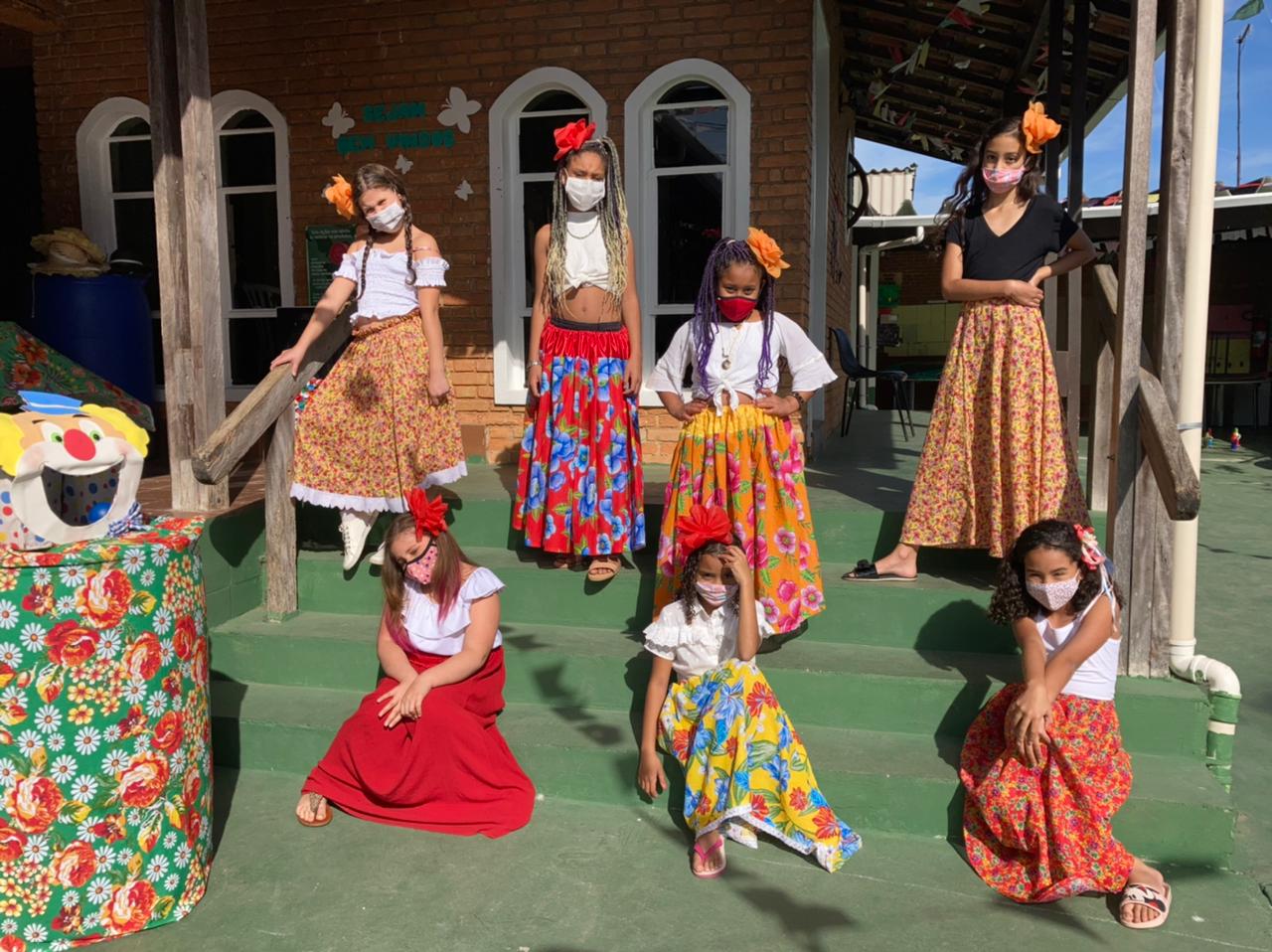 Meninas vestidas a caráter junino para realizarem a apresentação de dança nordestina.