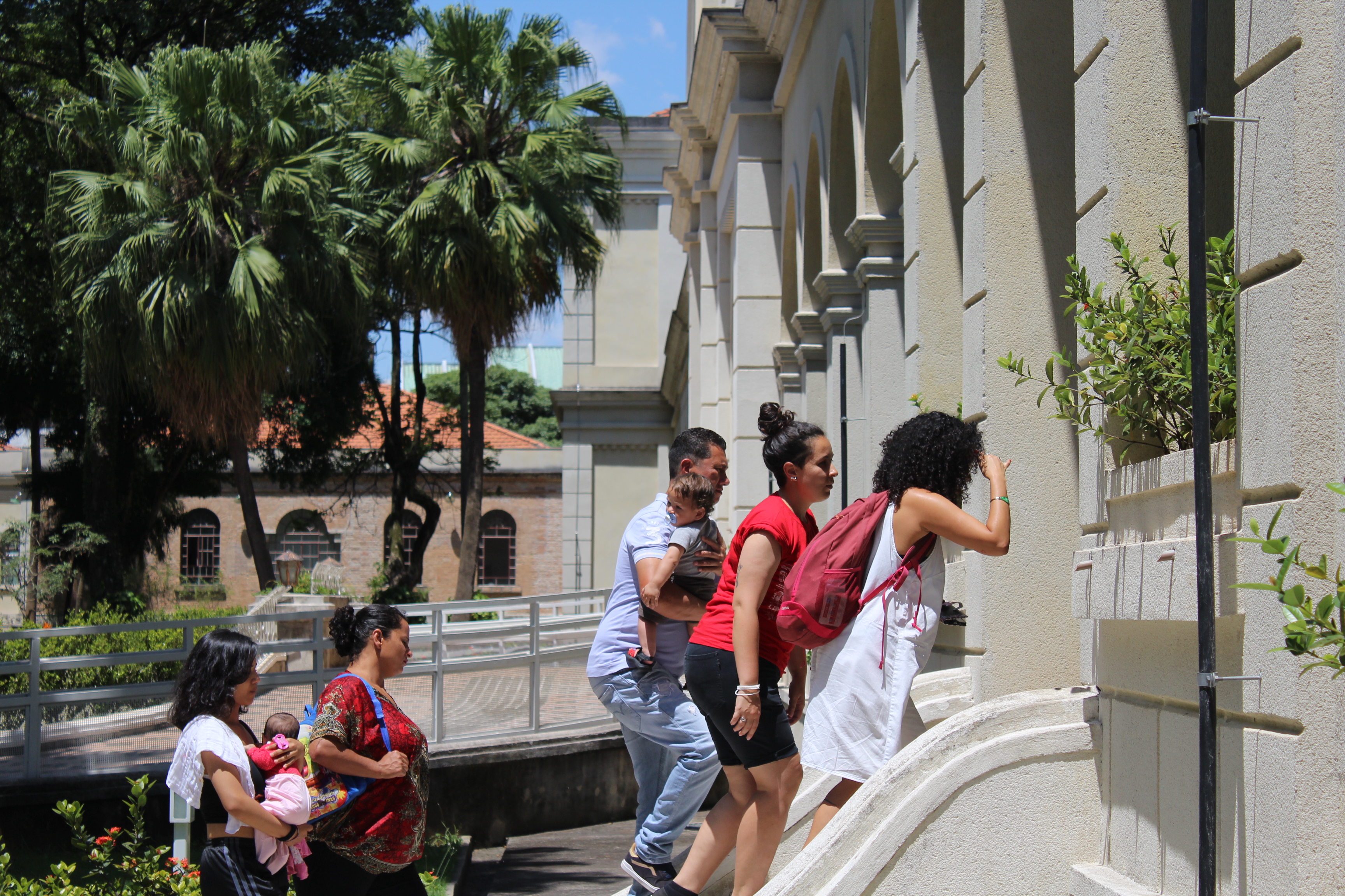 Grupo de conviventes adentrando o museu da imgração acompanhados por monitora