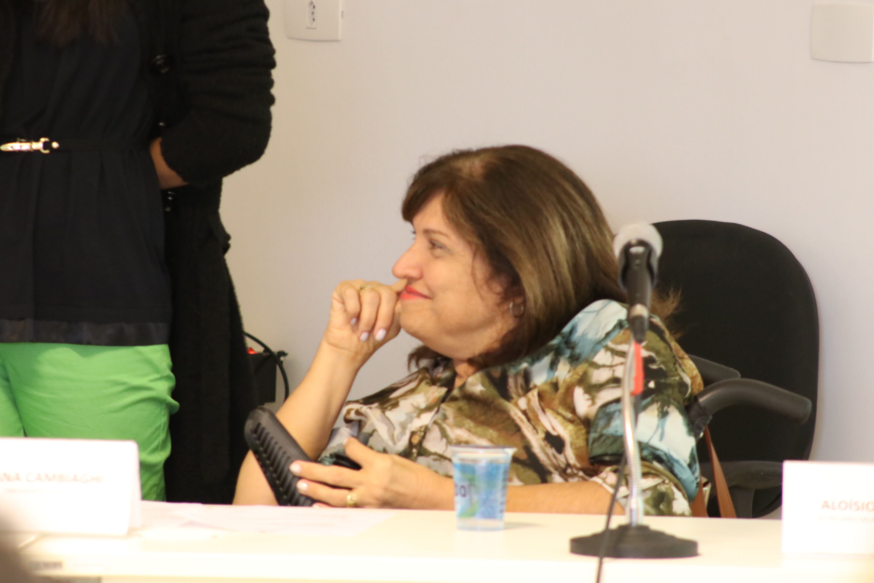 foto da Presidente da CPA Silvana Cambiaghi, sorrindo e atrás de uma mesa. Ela usa uma cadeira motorizada.