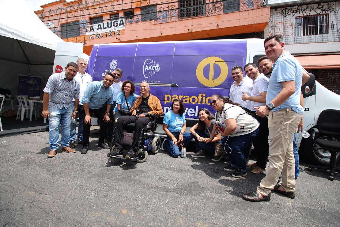 mais de quinze pessoas na foto, entre elas o secretário Cid Torquato em frente da van da Paraoficina Móvel.