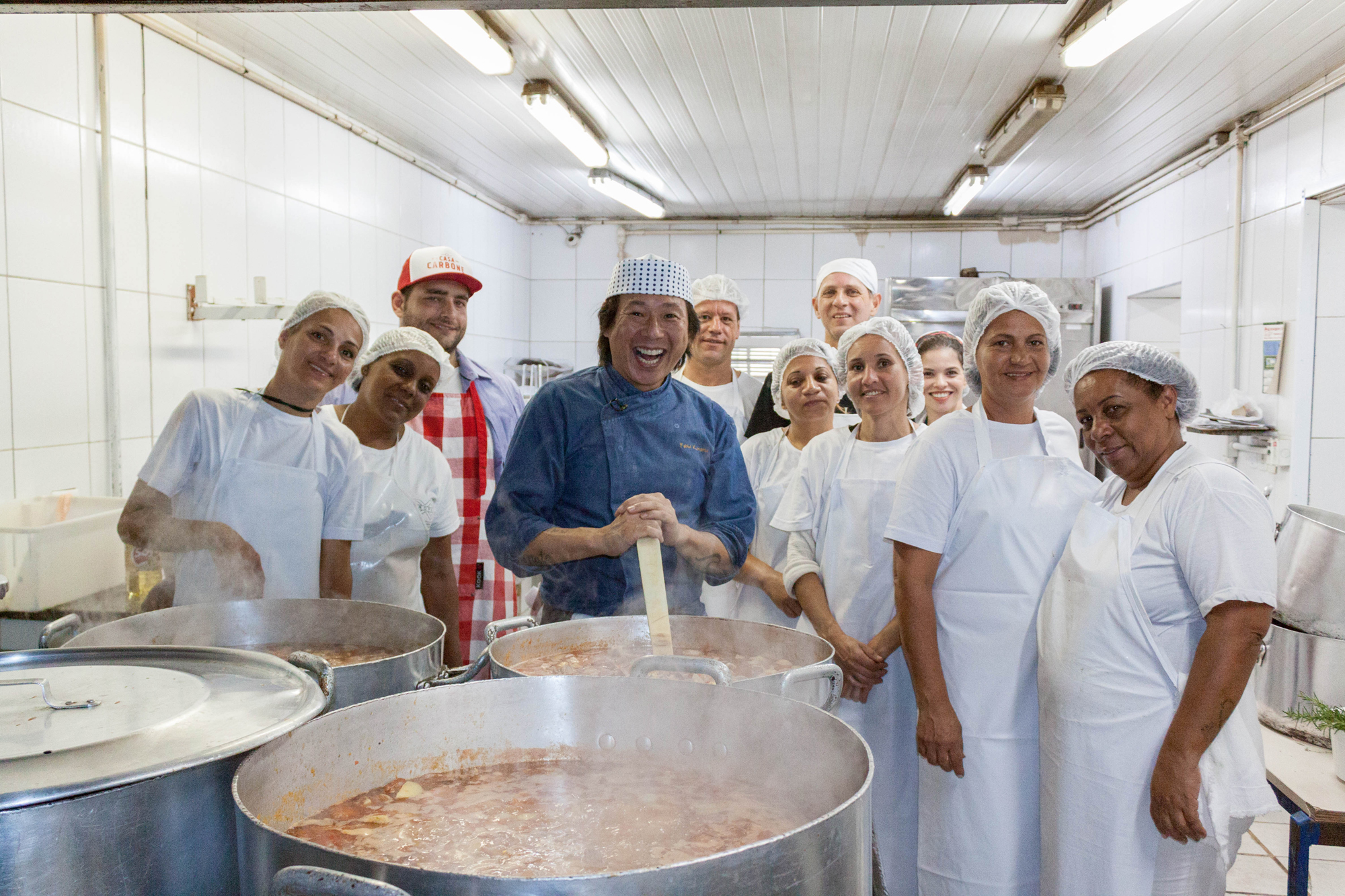o chef de cozinha Fábio Minato posa para foto com cozinheiras do serviço e voluntários. 