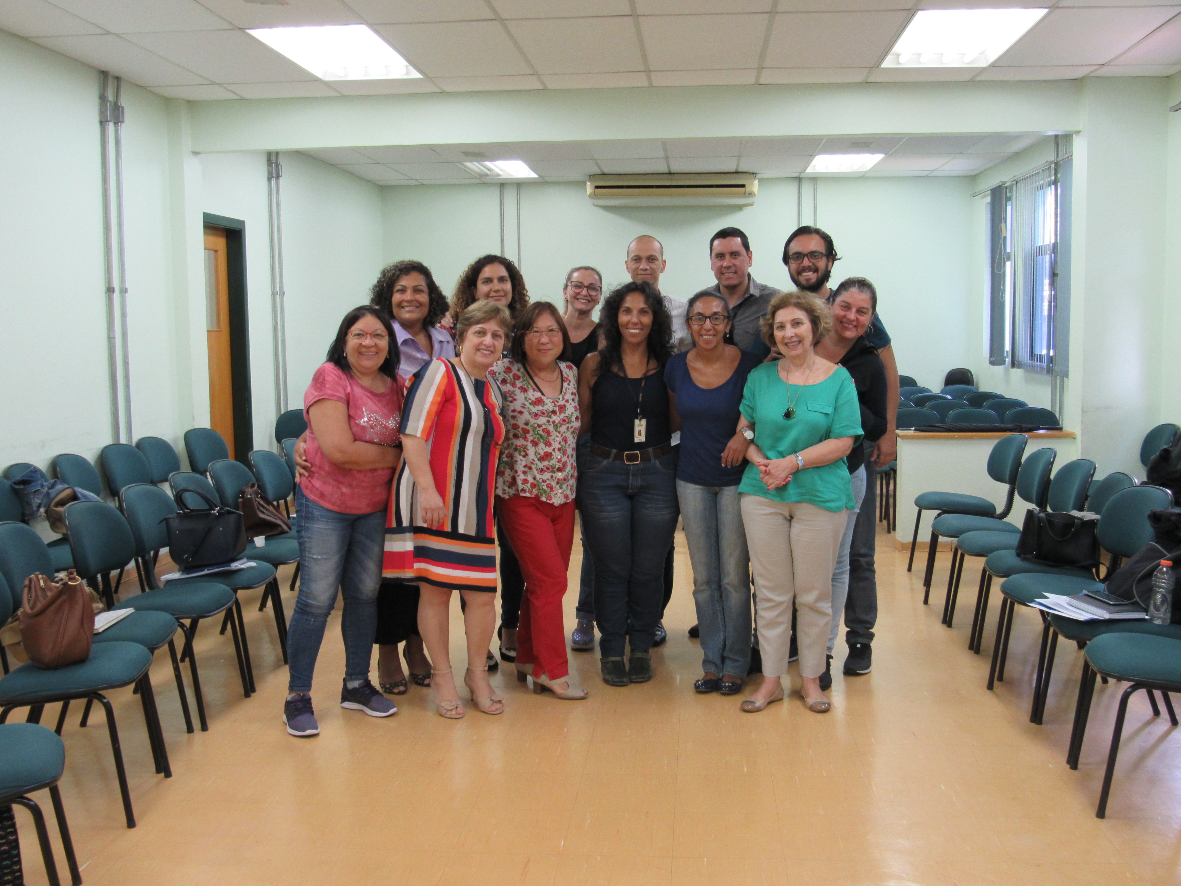 Dez mulheres e três homens em pose para foto no centro da sala de aula em pé