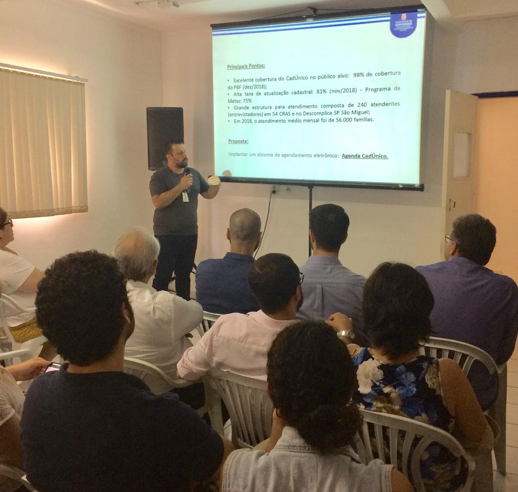 Coordenador de Gestão de Benefícios da SMADS explica Power Point para plateia 
