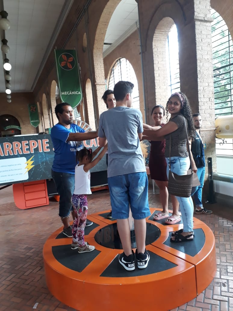 Jovens usuários do serviço em cima de brinquedo giratório no Museu Catavento