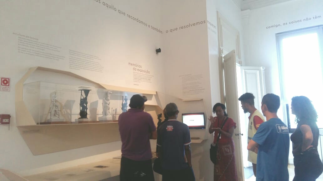 Dois usuários do serviço acompanham explicação de monitora em frente às peças expostas no museu 