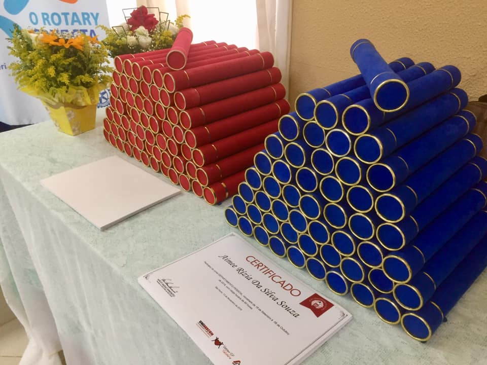 Dezenas de canudos nas cores vermelho e azul empilhados sobre mesa. 