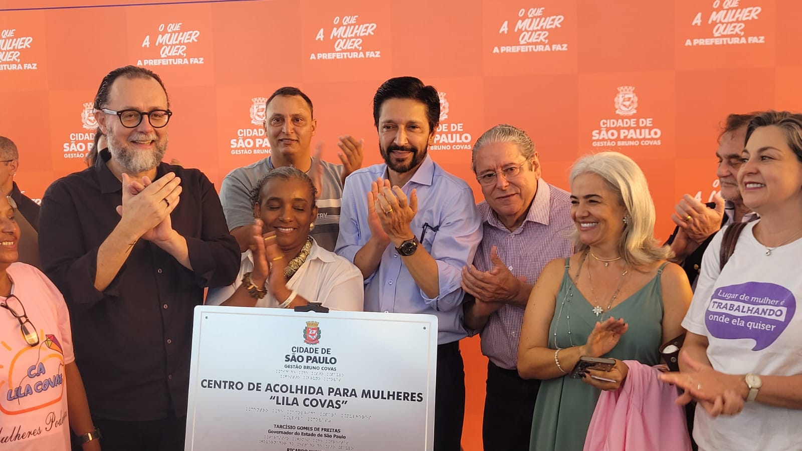 Em frente a um painel com os dizeres 
