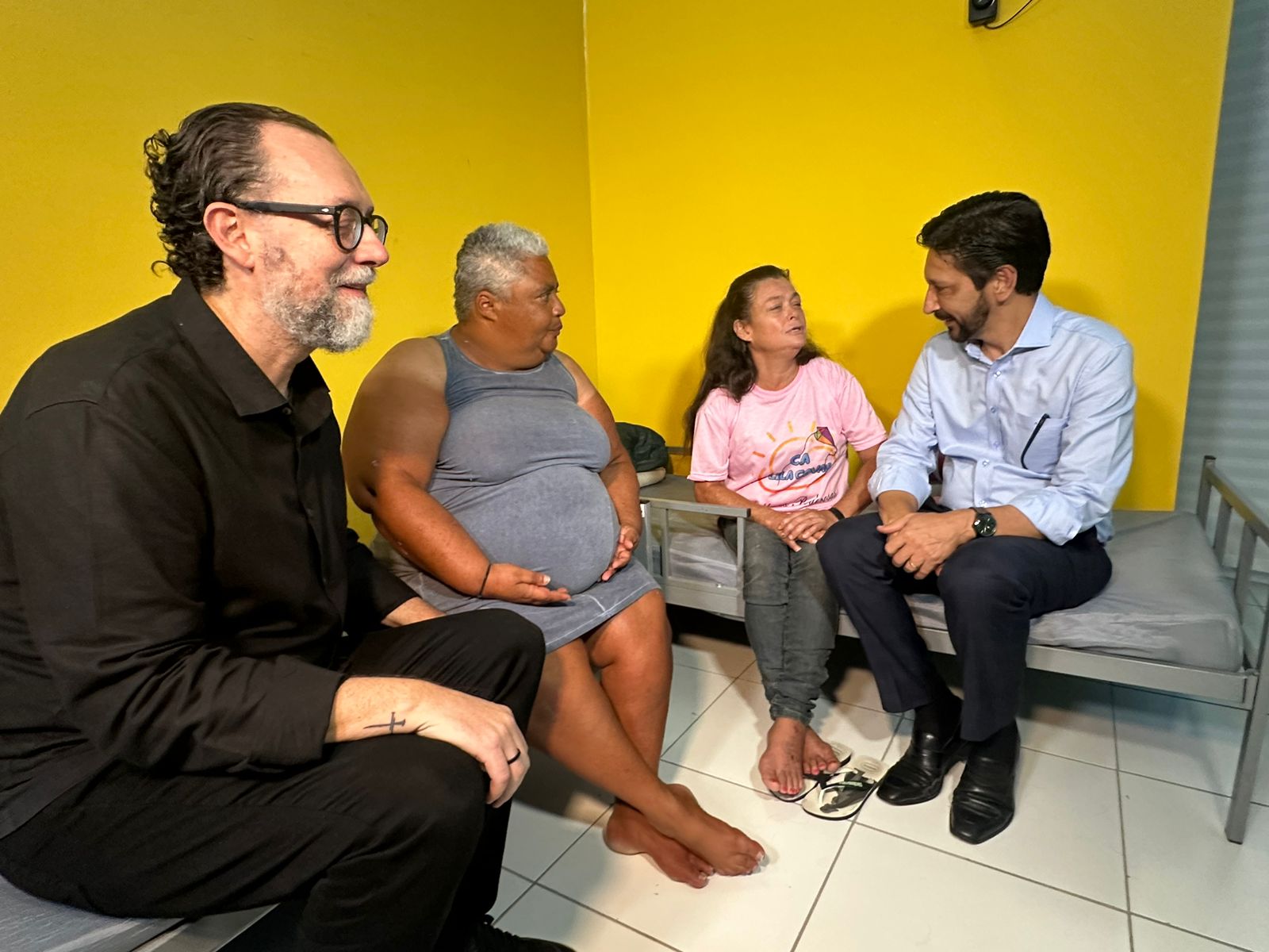 O secretário de Assistência e Desenvolvimento Social, Carlos Bezarra Júnior, e o Prefeito Ricardo Nunes conversam com duas mulheres acolhidas no CA  Lila Covas