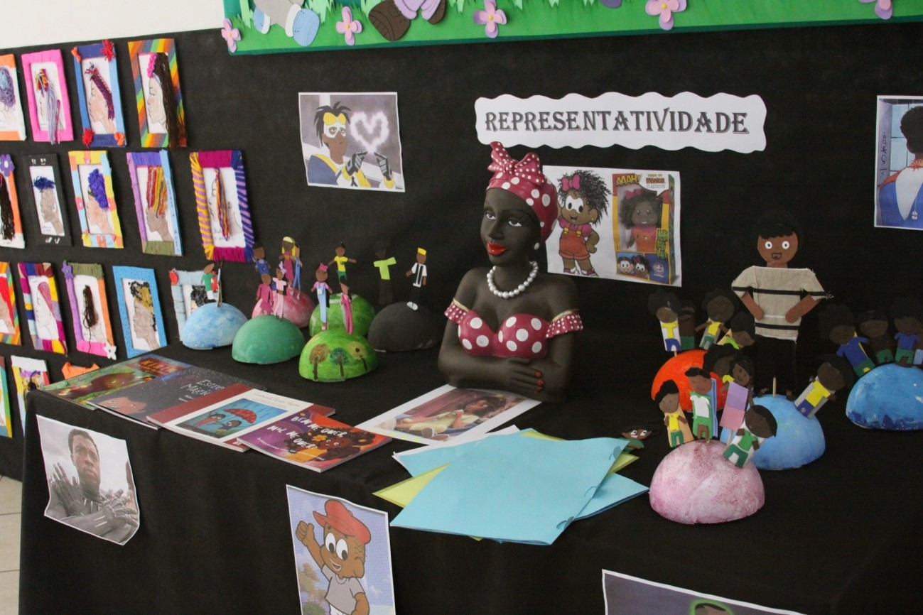 Mesa da representatividade, com personagens de filmes, desenhos e brinquedos negros .