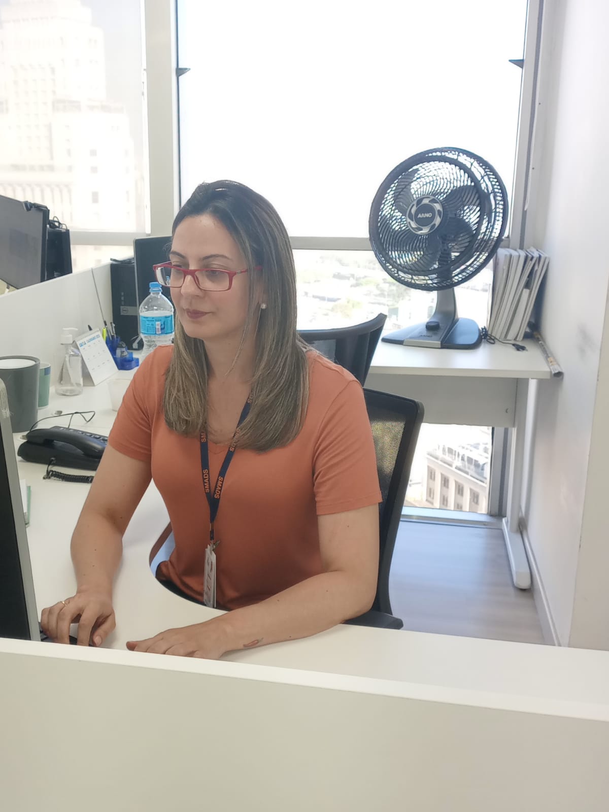 Mulher sentada em frente a um computador.