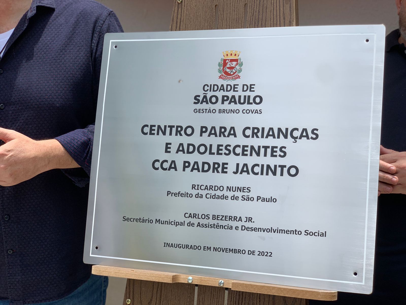 Placa do serviço CCA ‘Padre Jacinto’ apoiada no cavalete na cerimônia de inauguração.