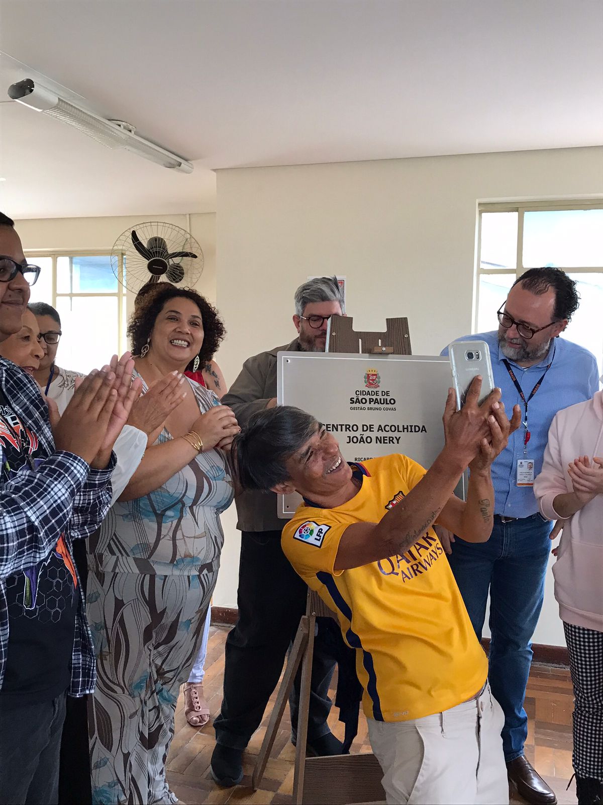 Na foto estão o Secretario da pasta Carlos Bezerra Jr., o Secretario Adjunto Décio Matos, os acolhidos e colaboradores em volta da placa de inauguração do CAE Casa Florescer João W. Nery