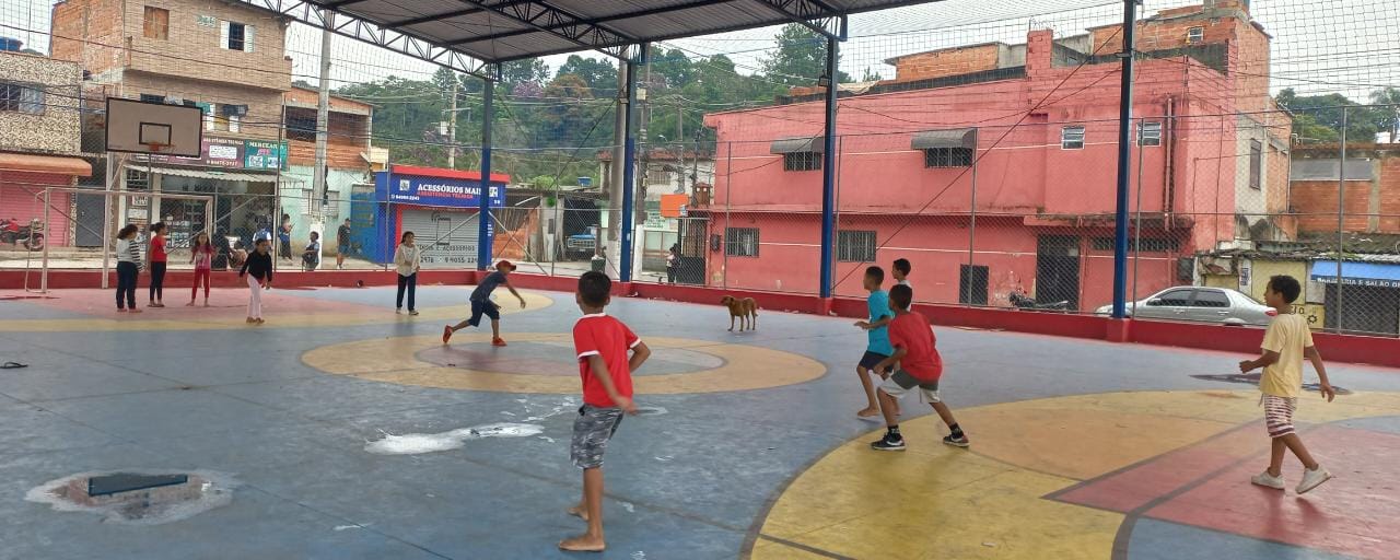 Crianças jogando uma partida de queimada na quadra poliesportiva do bairro Jardim São Norberto