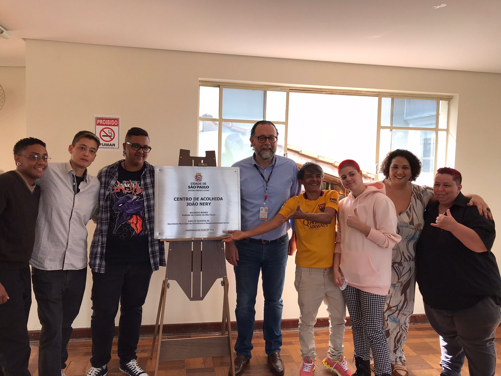 Na foto estão o Secretario da pasta Carlos Bezerra Jr. e os acolhidos em volta da placa de inauguração do CAE Casa Florescer João W. Nery.