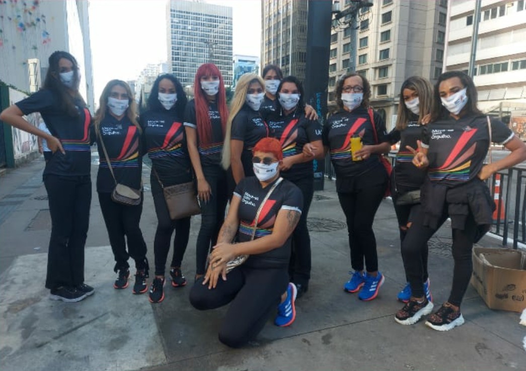 Na calçada da Avenida Paulista estão 11 acolhidas pela casa florescer posando para a foto com camisetas e máscaras com o tema da ação