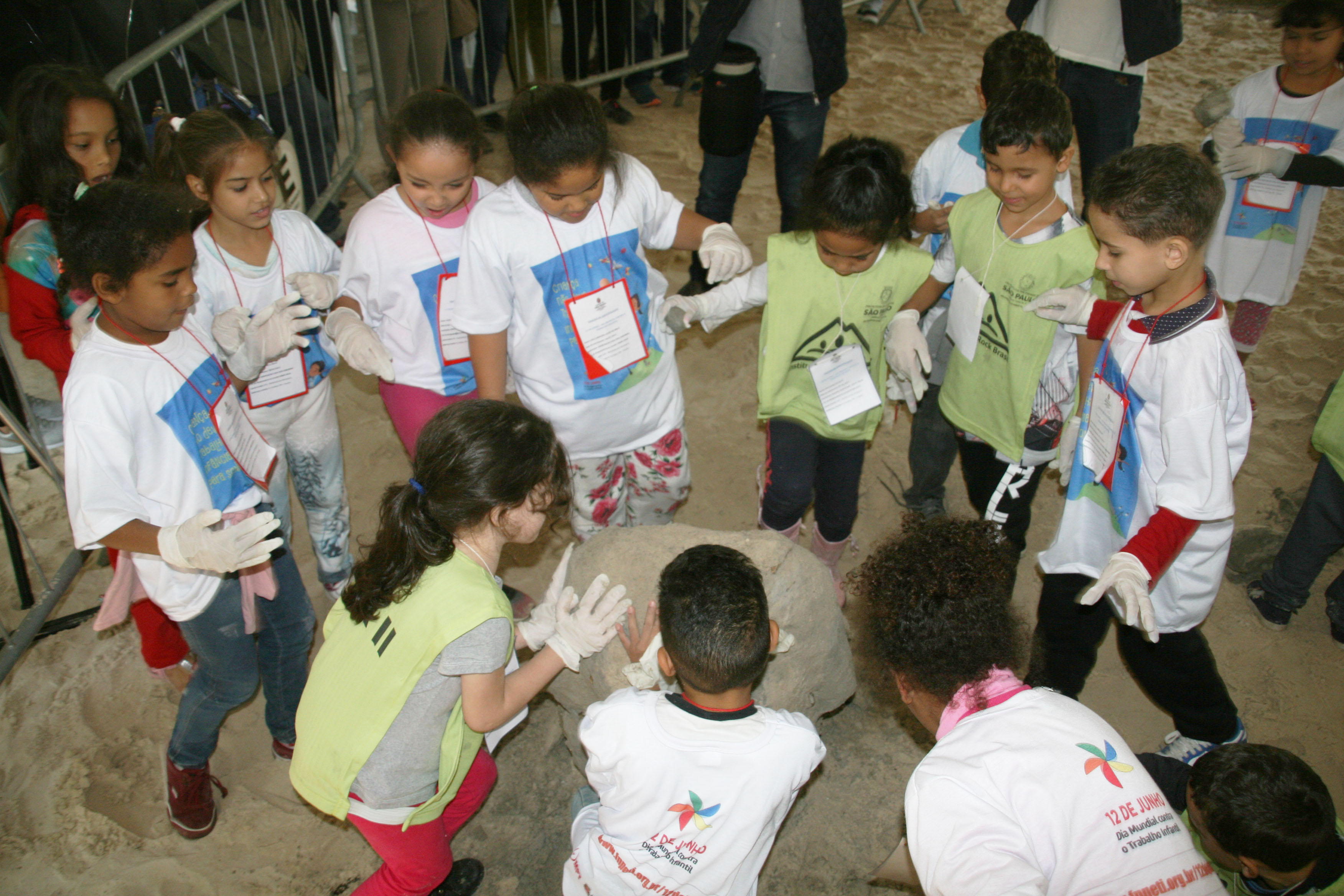 Doze crianças, entre meninos e meninas, destroem escultura de areia em tenda do evento no Parque Ibirapuera